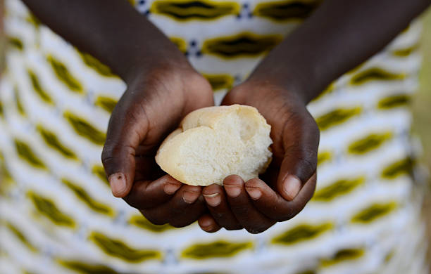 Starving Hunger Symbol. Black African girl holding bread to as a malnutrition symbol. It is important to get food and life-saving aid to the world’s most vulnerable people and countries. Stop hunger in the world!